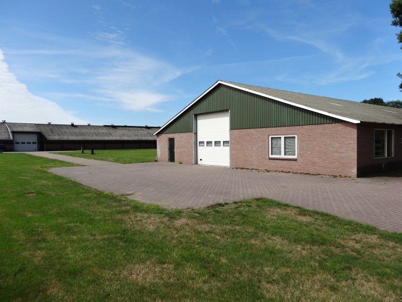 Onze overdekte stalling met groene gevel en ruim erf in Ambt Delden